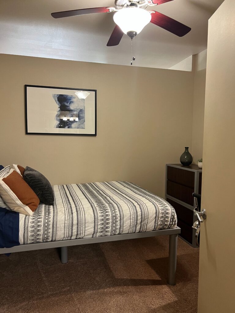 A cleaned and tidied bedroom with a bed on risers