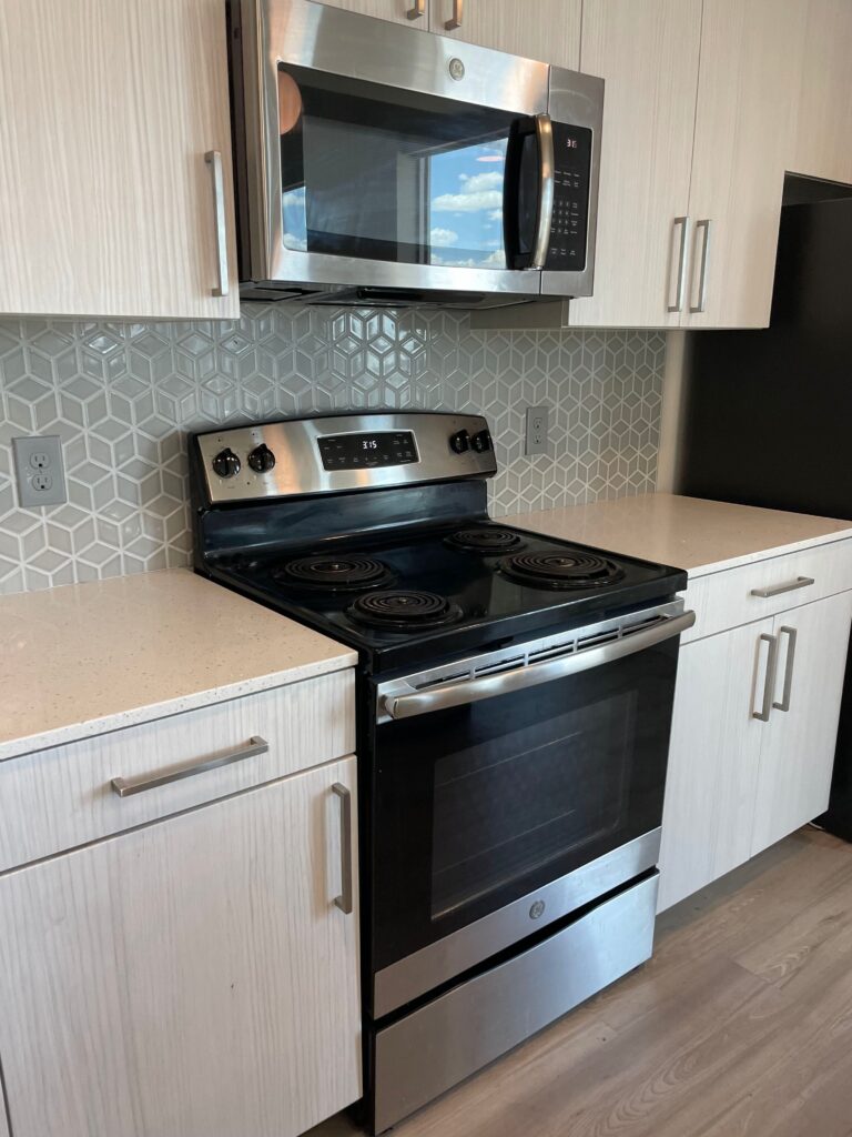A cleaned kitchen with stainless steel appliances and white cabinets